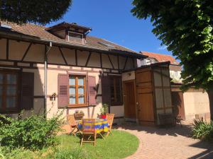 a house with a table and chairs in the yard at Petite maison SOUS LE TILLEUL in Schiltigheim