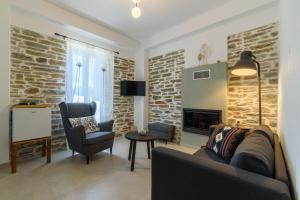 a living room with a couch and a chair and a fireplace at Orange House - Lower West appartment in Promírion +2 photos