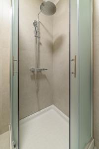 a shower with a glass door in a bathroom at Orange House - Lower West appartment in Promírion