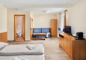 a hotel room with two beds and a couch at Penzion Čítkův Mlýn in Šluknov +25 photos