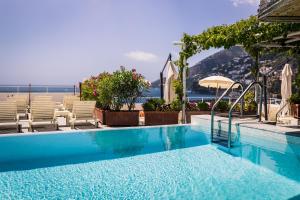a swimming pool with chairs and a view of the ocean at Hotel Marina Riviera in Amalfi