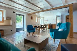 ein Wohnzimmer mit blauen Stühlen und einem Tisch in der Unterkunft Jurabelle in La Côte-aux-Fées