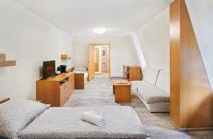 a living room with two beds and a couch at Penzion Čítkův Mlýn in Šluknov