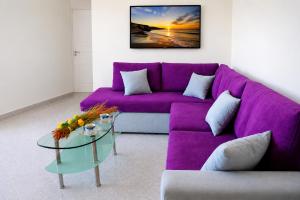 a purple couch in a living room with a glass table at Aias Summer House in Aiándion