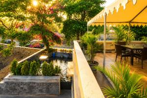 a garden with a pond and tables and trees at Bungalow Seven Mount Abu in Mount Ābu