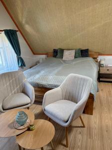 a bedroom with a bed and two chairs at Pension 311 Vrchlabí in Vrchlabí