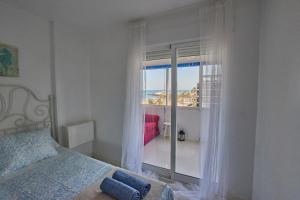 a bedroom with a window with a view of the ocean at Beachfront Apartment with Sea Views & Pool - El Puig in El Puig