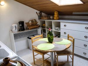 a kitchen with a table with a vase on it at Santon in Eugénie-les-Bains