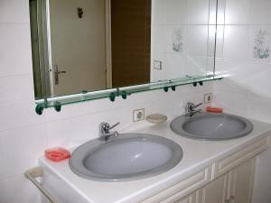 a bathroom with two sinks and a mirror at Santon in Eugénie-les-Bains