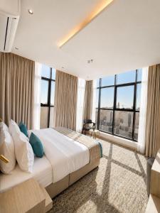 a bedroom with a large bed and large windows at فندق النقاط الثمانية 2 in Medina