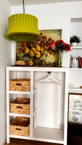 a lamp on top of a white shelf with flowers at Wanderer und Radlerzimmer in Lieser