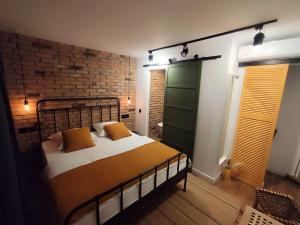 a bedroom with a bed and a brick wall at Casa FaRa in Vama Veche