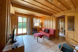 a living room with a red couch and a tv at Apartman Pepa in Bayerisch Eisenstein