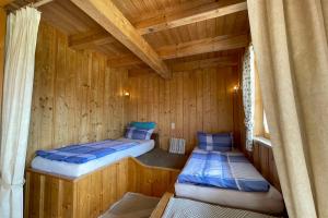 a room with two beds in a wooden cabin at Apartman Pepa in Bayerisch Eisenstein
