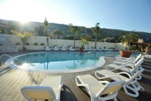 a group of chairs and a swimming pool at Hotel la Praia in Zambrone