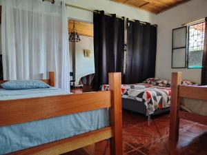 a bedroom with two beds and a window at EcoHonda Low Cost in Honda