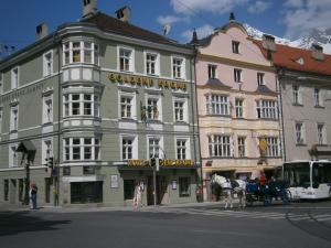 uma carruagem puxada por cavalos em frente a um edifício em Hotel Goldene Krone Innsbruck em Innsbruck