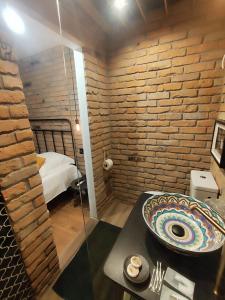 a bathroom with a sink and a brick wall at Casa FaRa in Vama Veche