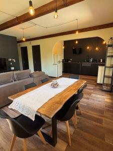 a dining room table with chairs and a kitchen in the background at Il Cantuccio delle Crete in Asciano