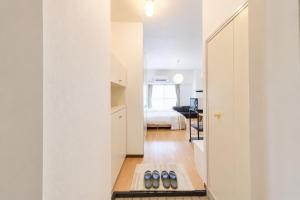a hallway with a kitchen and a bedroom with a bed at 宇都宮ハウスシラユリ in Utsunomiya