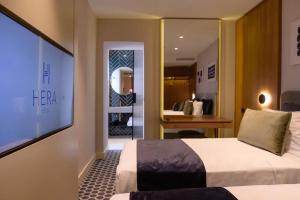 a hotel room with a bed and a desk and a mirror at Hera Hotel in Alexandroupoli