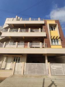 a tall building with white doors and a balcony at SV Serviced Apartments in Chikmagalūr