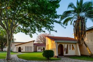 a house with a palm tree in front of it at Kadoma Hotel & Conference Centre in Kadoma