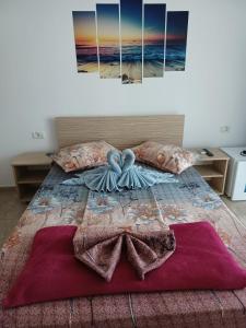 a bedroom with a bed with two paintings on it at Vila Lara 2 Mai in 2 Mai