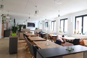 a restaurant with wooden tables and chairs and windows at alla Papa in Obernzenn
