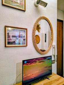 a flat screen tv sitting on a table with a mirror at Tiny home in Camigliatello Silano