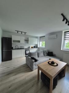 a living room with a couch and a table at Sowi Zakątek in Jugów
