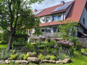 a garden in front of a house with flowers at Sowi Zakątek in Jugów