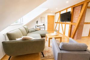 a living room with two couches and a tv at Ferienwohnungen an der alten Stadtmauer in Blankenburg