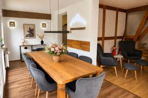 a dining room with a wooden table and chairs at Ferienwohnungen an der alten Stadtmauer in Blankenburg
