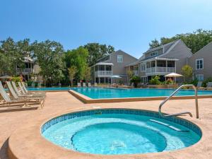 a large swimming pool in a yard next to a house at Hidden Dunes Beach Cottage 208- Dune Our Thing in Destin