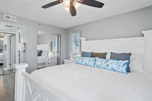 a bedroom with a white bed with a ceiling fan at SunDestin 818 in Destin +48 photos