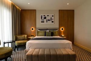 a hotel room with a large bed and a chair at Hera Hotel in Alexandroupoli