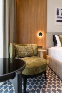 a hotel room with a chair and a bed at Hera Hotel in Alexandroupoli +68 photos