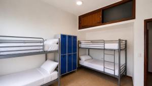 a room with bunk beds and a flat screen tv at Guayaba Hostel in Las Lagunas +4 photos