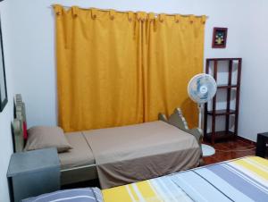 a room with two beds and a yellow curtain at Brisas de la Bujona in Honda