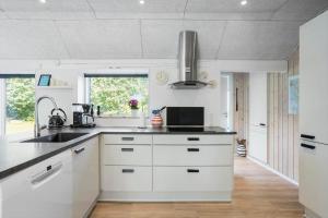 a kitchen with white cabinets and a sink at FY180-Asperup-Daadyrvaenget-18 in Asperup +16 photos