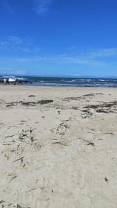 a beach with footprints in the sand and the ocean at Praia de Pitangui in Extremóz +9 photos