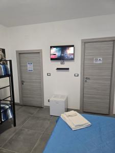 a room with two doors and a tv on the wall at Gli Amici della Puglia 2 in Taranto