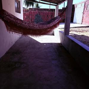 a patio with a hammock in front of a house at Praia de Pitangui in Extremóz