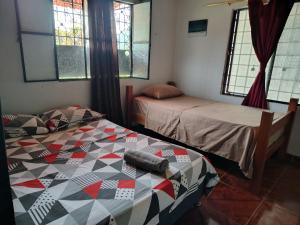 a room with two beds and two windows at Callejón del Sol in Honda