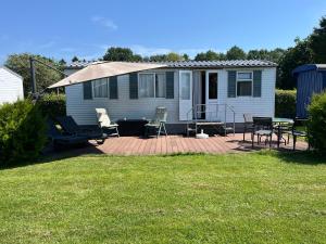 a house with a patio with chairs and a table at Camping BuitenRijk - Chalet D35 Huisdier vrij in Valthermond