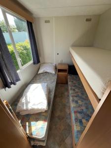a small room with two beds and a window at Camping BuitenRijk - Chalet D35 Huisdier vrij in Valthermond