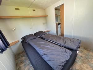 a small bedroom with a bed in a room at Camping BuitenRijk - Chalet D35 Huisdier vrij in Valthermond +1 photo