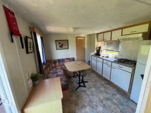 a small kitchen with a table in a tiny house at Camping BuitenRijk - Chalet D35 Huisdier vrij in Valthermond