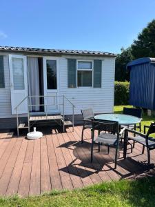 a patio with a table and chairs and a house at Camping BuitenRijk - Chalet D35 Huisdier vrij in Valthermond